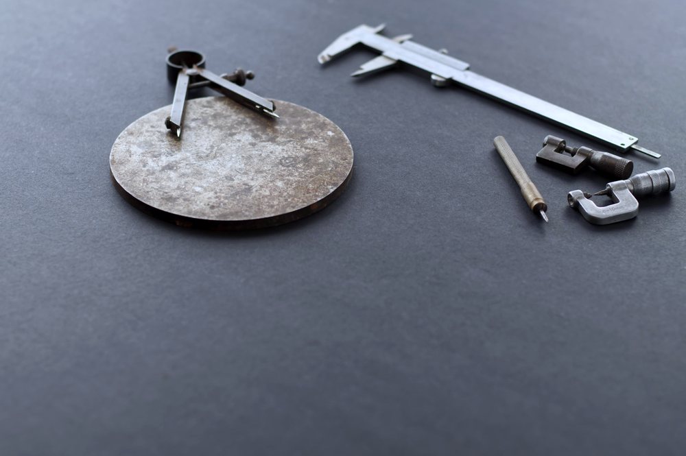 Precision measuring tools including callipers laid out on a black surface